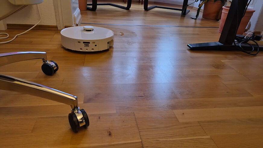 Der Roborock Qrevo Curv 2 Flow wischt im Alltag rund um Stuhlbeine und unter dem Esstisch.